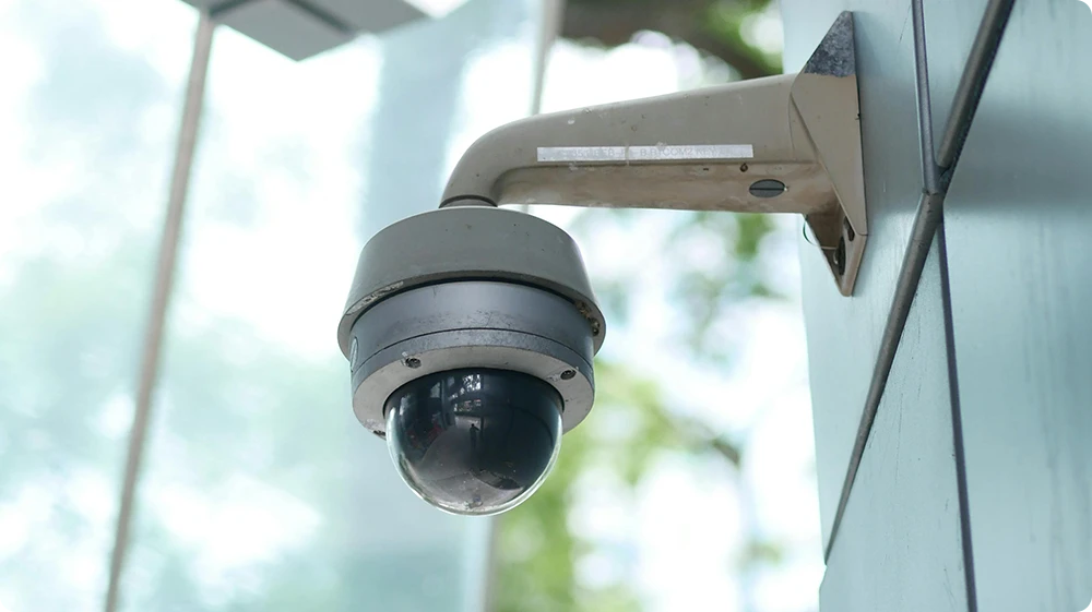 AI-powered surveillance camera installed on a commercial building wall for workplace safety and compliance monitoring.