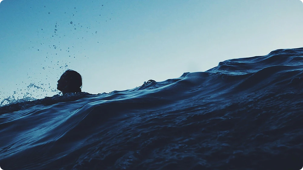 Person partially submerged in deep water, illustrating fear of drowning and aquaphobia