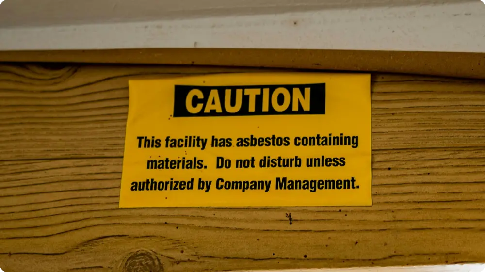 Caution sign indicating asbestos-containing materials, warning not to disturb without authorisation