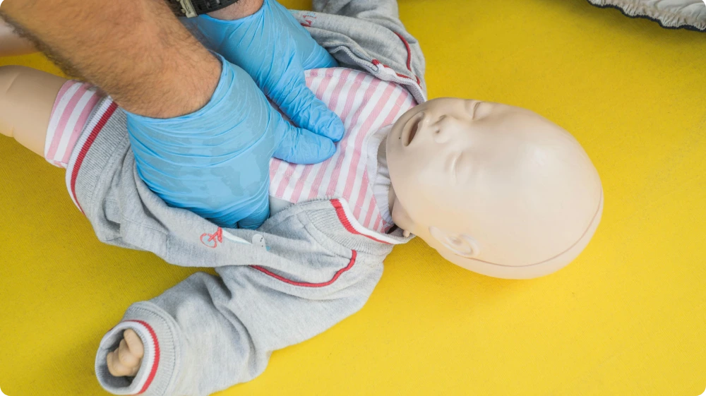 Instructor giving CPR to a baby during first aid training