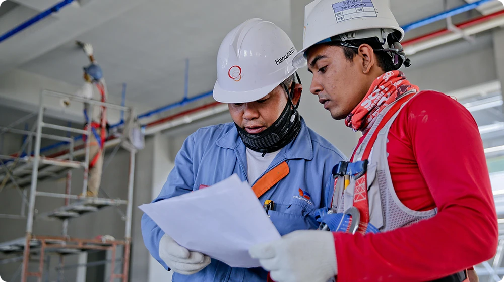 Two construction professionals discussing site plans as part of site manager duties
