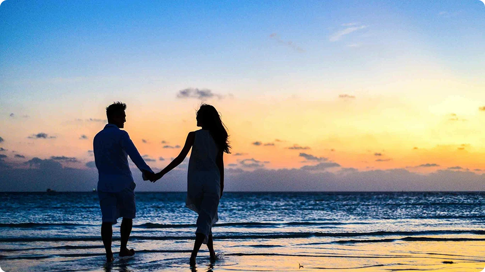 Couple holding hands by the sea, symbolising fear of commitment in gamophobia