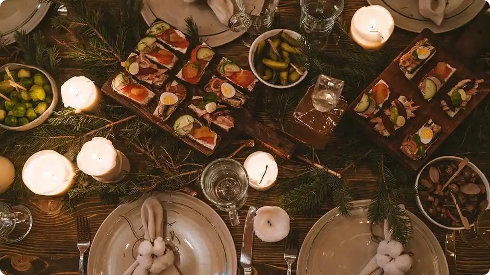 Overhead view of a table setting with candles, appetisers, and neatly arranged cutlery