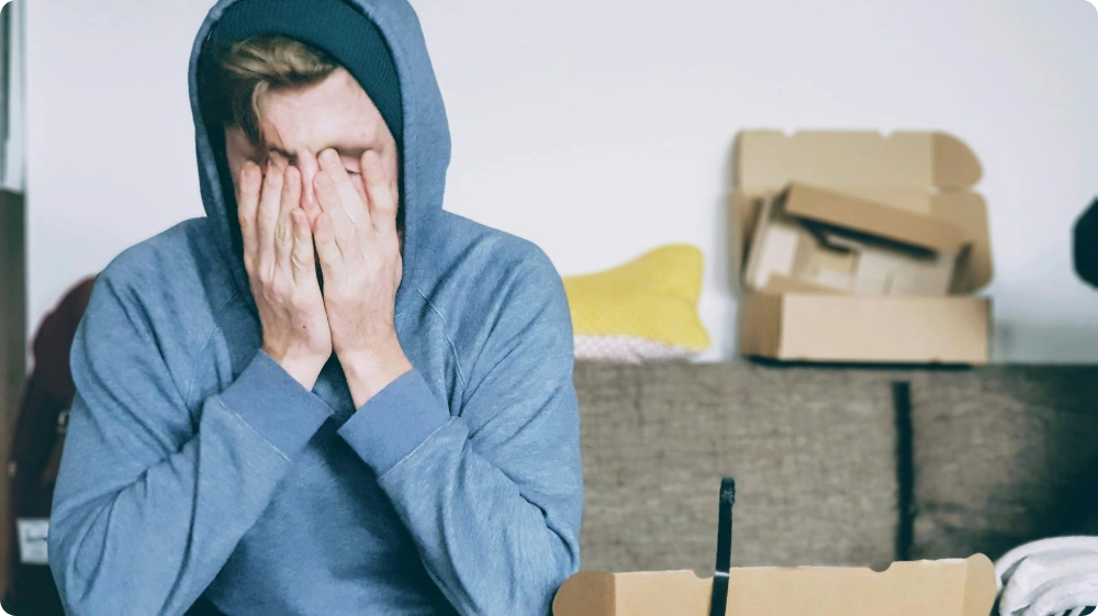 A man covering his face in distress, illustrating emotional reasoning