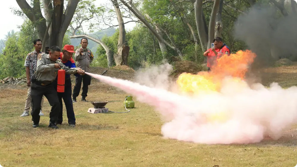 Fire safety training session with officers using a fire extinguisher to put out flames outdoors