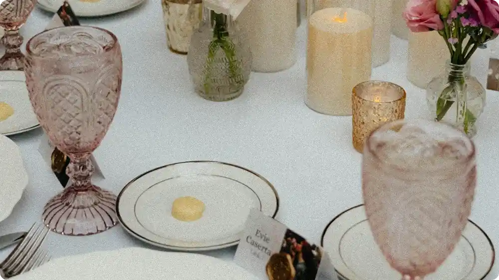 Elegant formal table setup with candles, flowers, and vintage glassware