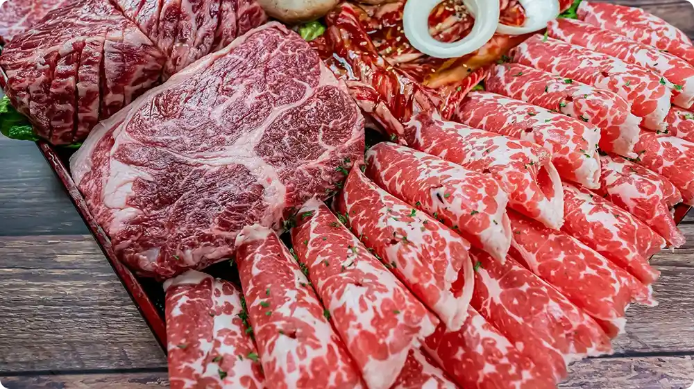 A wooden platter displaying various raw beef cuts, prepared for proper fridge or freezer storage.