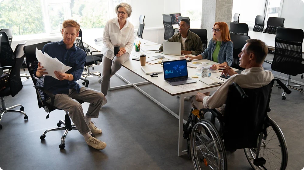 Four diverse individuals, including one person in a wheelchair, representing inclusive recruitment practices in schools committed to diversity.