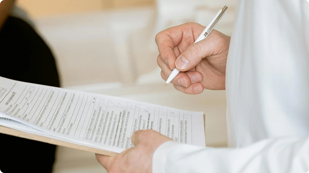 A man is filling out a workplace accident report in a workplace, documenting incident details.