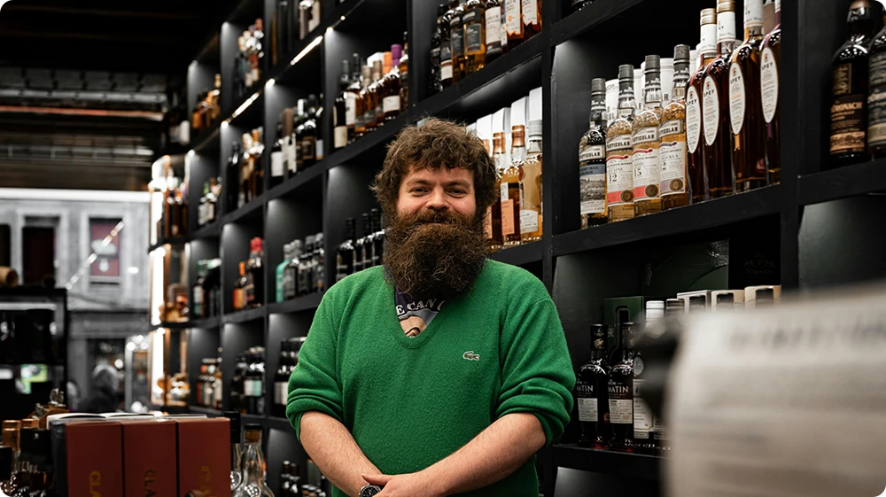 Man selling bottled alcohol at a Scottish shop, representing alcohol licensing under the Licensing (Scotland) Act 2005)