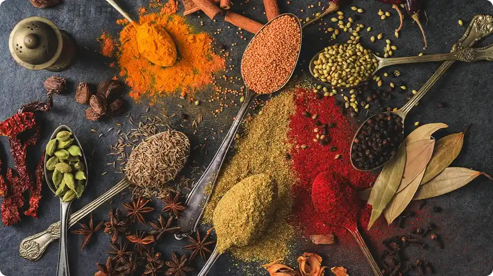 Various spices and herbs in spoons natural flavour enhancers used to create different flavour profiles in food.