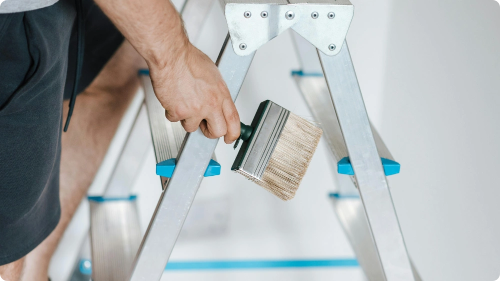  Painter climbing ladder during renovation - Hurak NVQ in Painting and Decorating