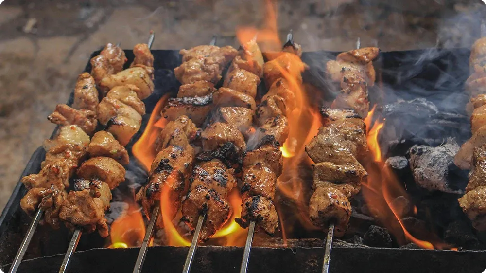 Cooked meat skewers being grilled thoroughly to ensure safe storage in the fridge