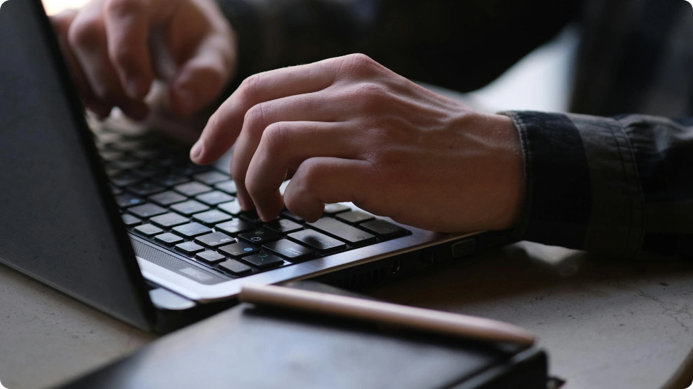 Security professional writing an SIA report on a laptop example incident report writing process in action.