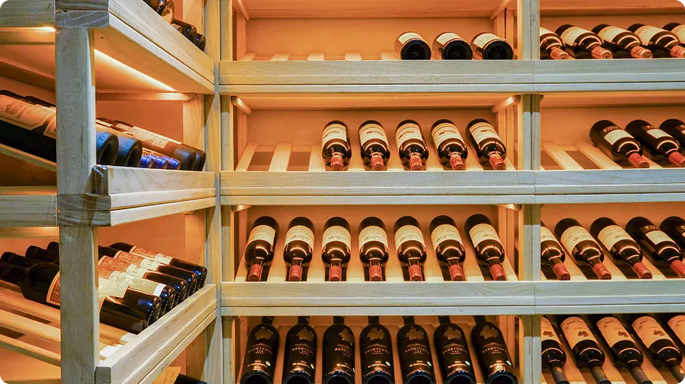 Bottles of wine and liquor neatly stocked in a cellar, ready for sale online.