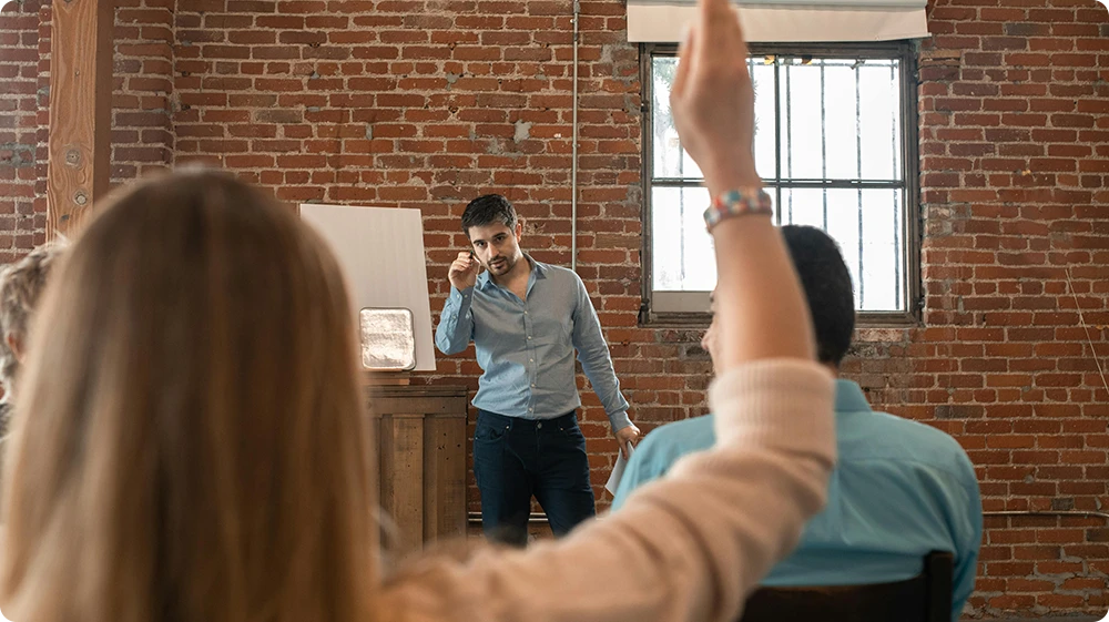 Teaching assistant interacting with students in a modern classroom setting during a discussion