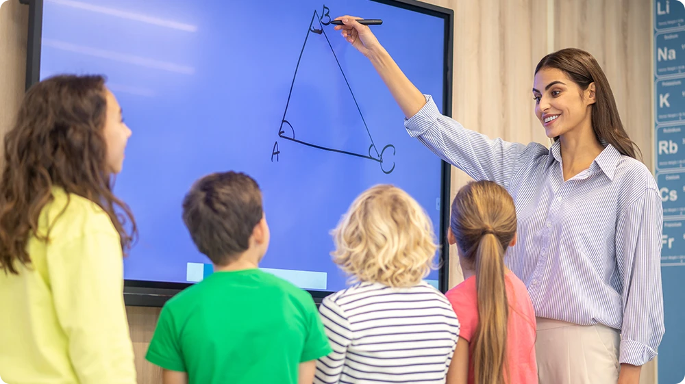  Teacher surrounded by children, guiding them as they explore, fostering a learning environment and engaging with students to encourage curiosity and awareness.