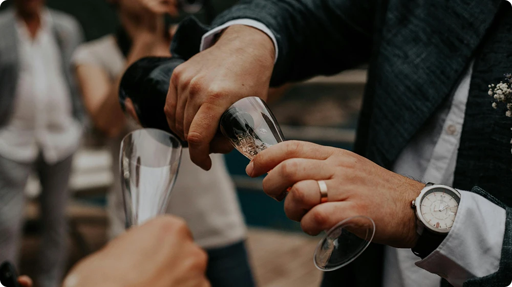 Man serving champagne at an event with a TEN alcohol licence in the UK
