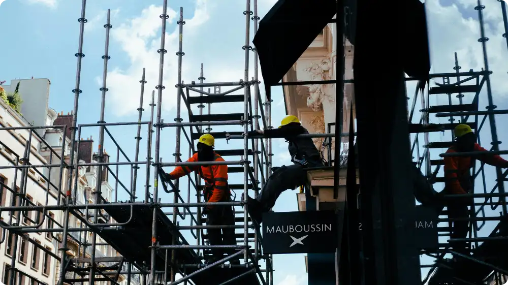 Construction worker standing on a scaffold, highlighting the importance of risk assessment and safety measures.