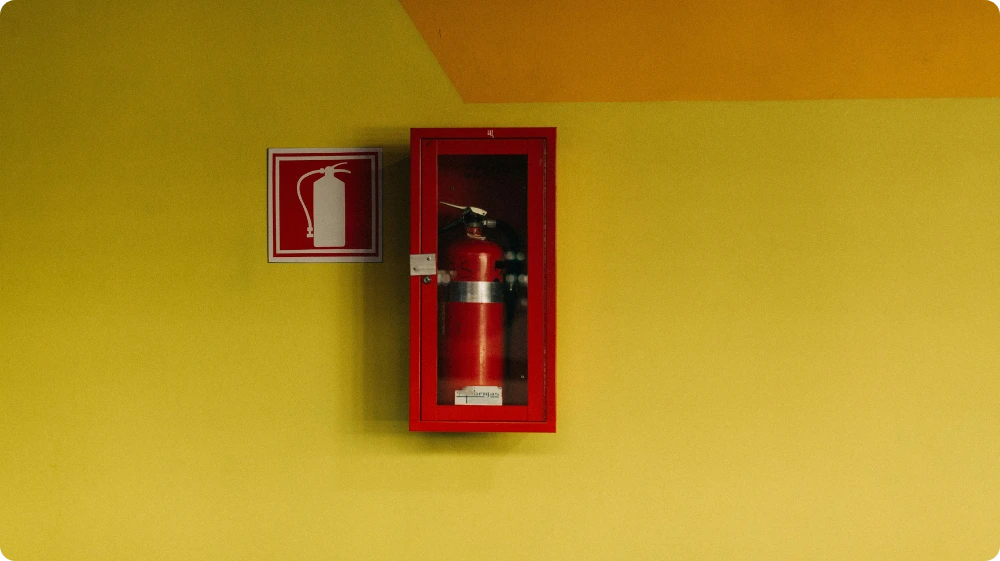 Mounted fire extinguisher in a red wall cabinet for workplace fire safety compliance