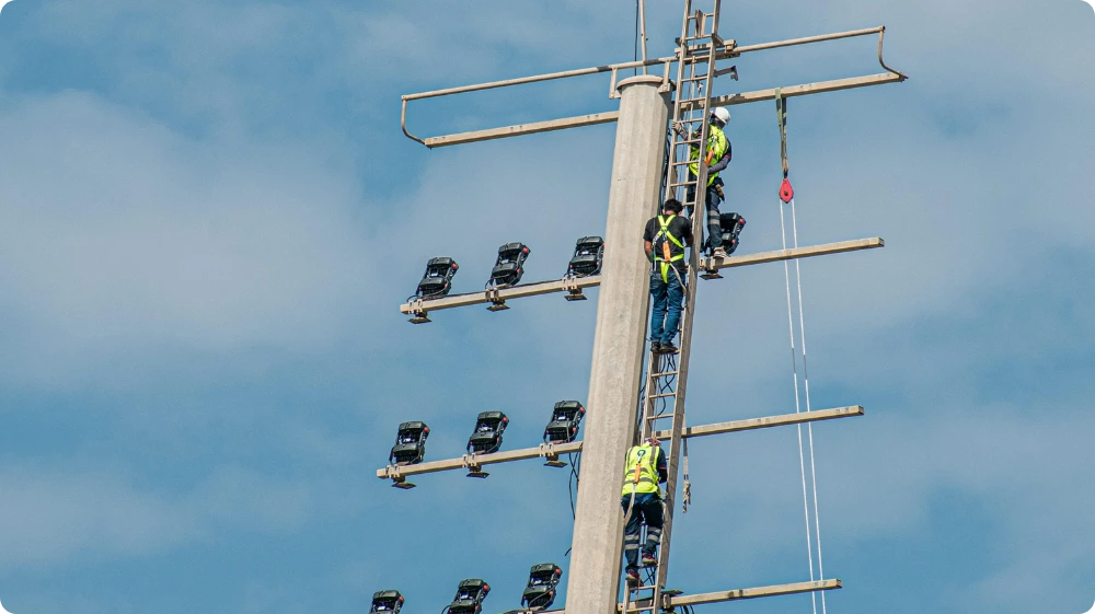Worker wearing a safety harness while working at height on a construction site 