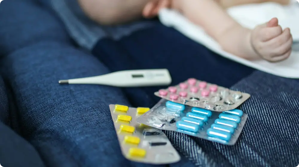 Baby with thermometer showing fever or hypothermia risk