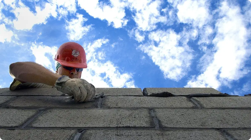 Bricklayer working on a construction site under a blue sky 