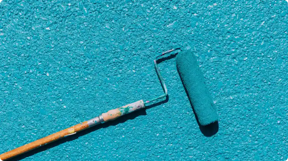 Blue wall being painted with roller - Hurak NVQ Painting and Decorating