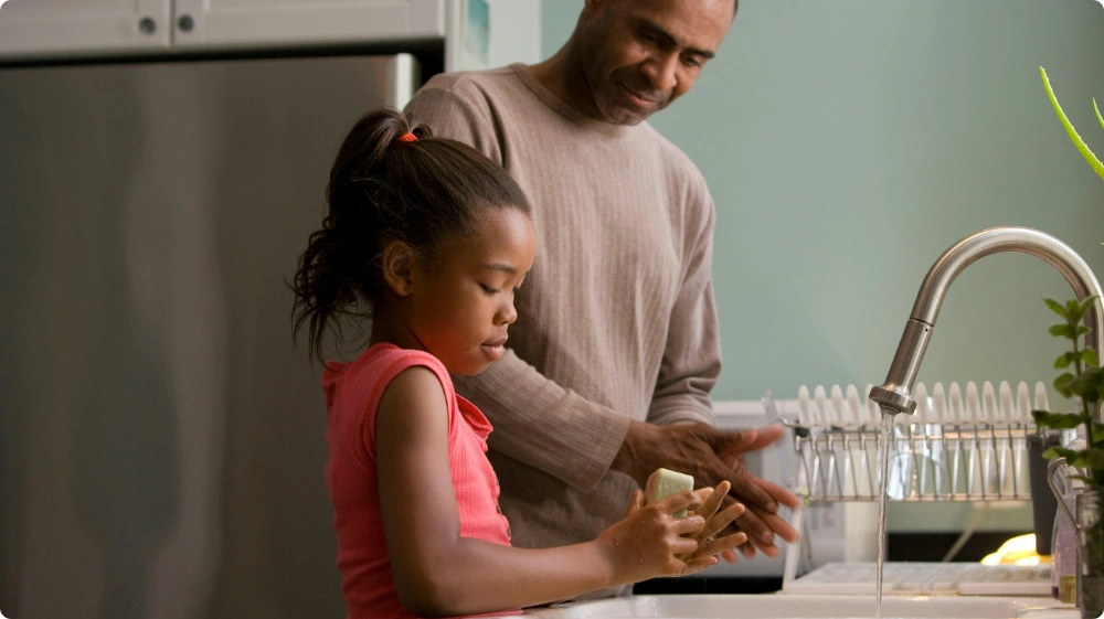 Child washing hands with soap and water as a preventive measure against scarlet fever infection
